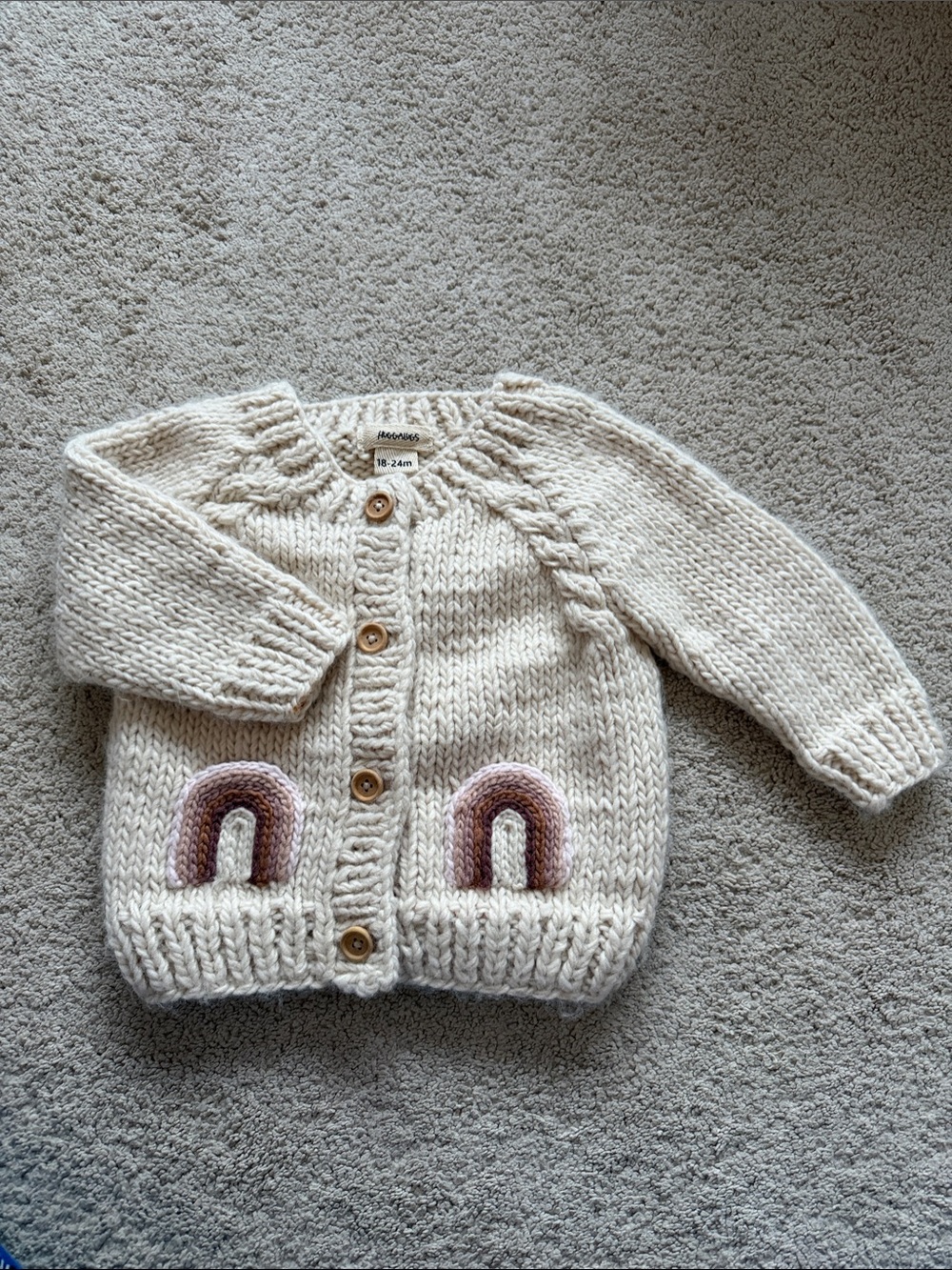Huggalugs Hand-Knit Cream Baby Cardigan with Rainbow Pockets